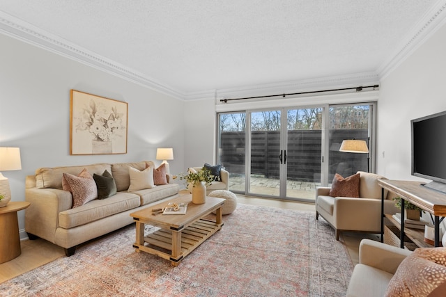 living room featuring ornamental molding, a textured ceiling, and wood finished floors