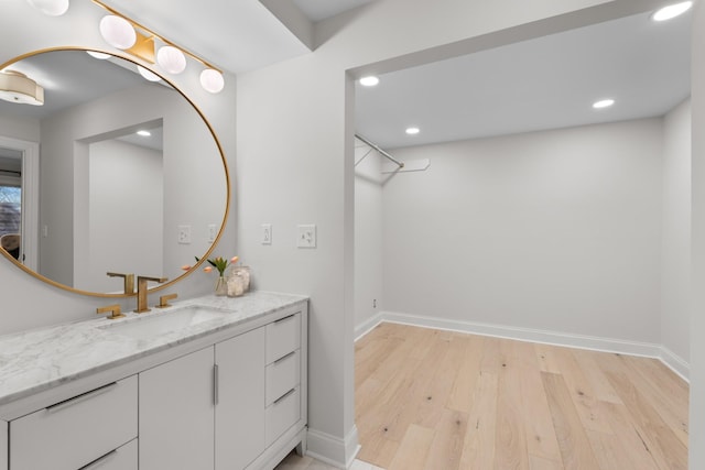 bathroom featuring recessed lighting, vanity, baseboards, and wood finished floors