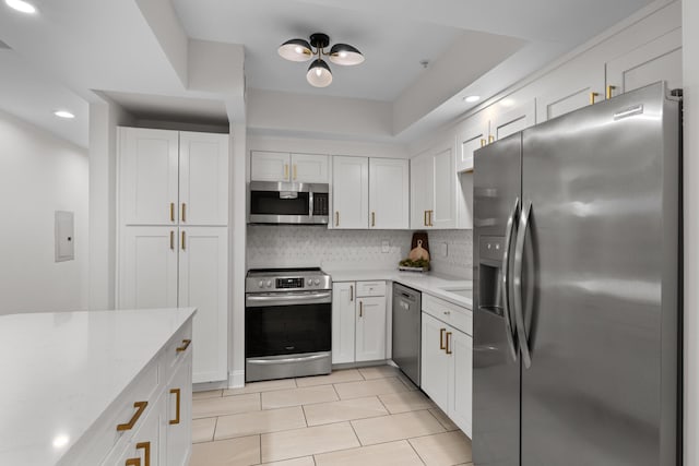 kitchen with stainless steel appliances, electric panel, white cabinets, and backsplash