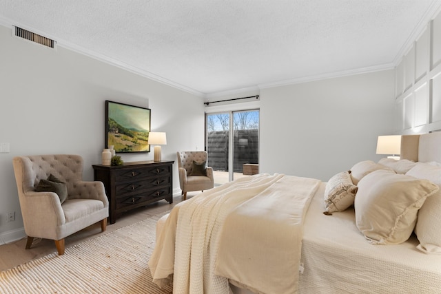 bedroom with a textured ceiling, visible vents, access to outside, light wood finished floors, and crown molding