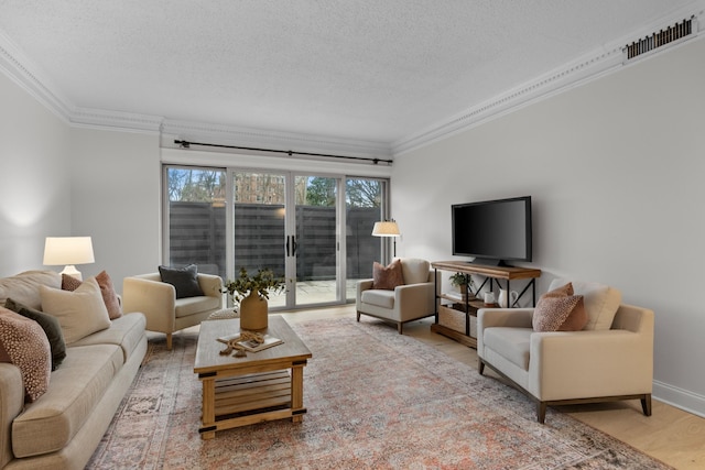 living room with a textured ceiling, wood finished floors, visible vents, baseboards, and crown molding