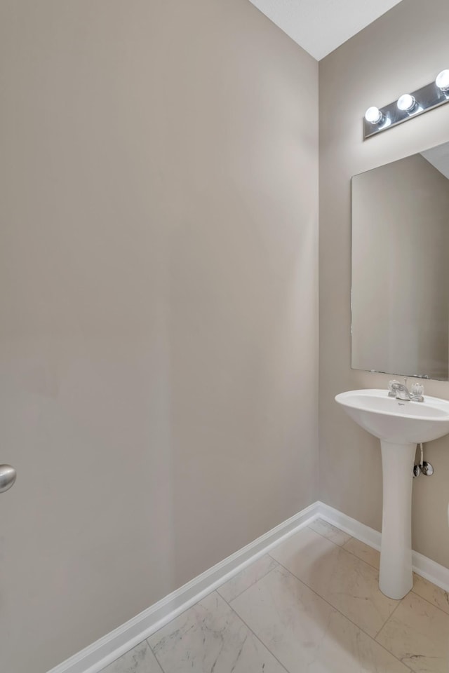 bathroom with marble finish floor and baseboards