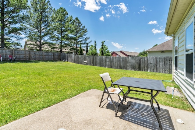 view of yard featuring a fenced backyard, outdoor dining area, and a patio