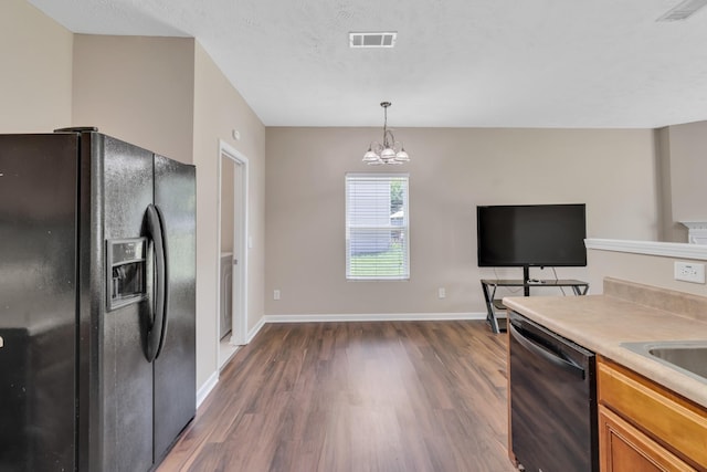 kitchen with dark wood finished floors, visible vents, black refrigerator with ice dispenser, dishwasher, and baseboards