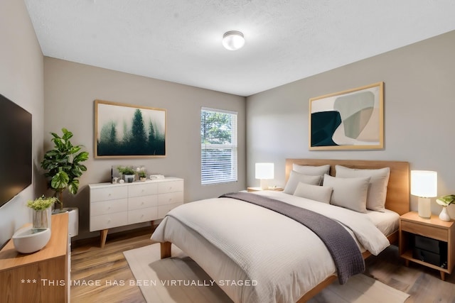 bedroom featuring a textured ceiling and wood finished floors