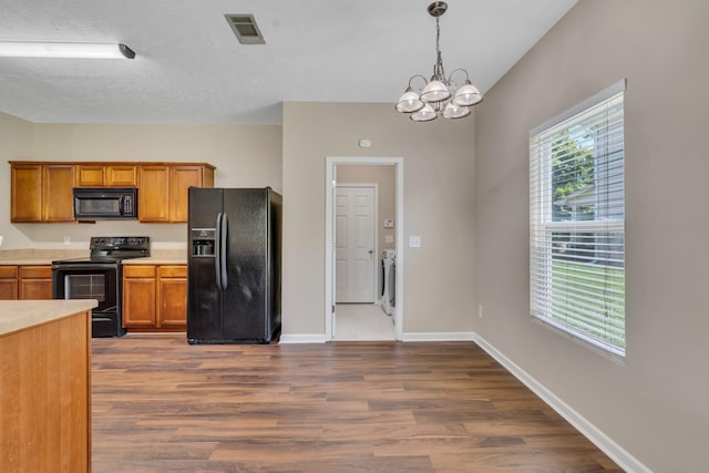 kitchen featuring visible vents, brown cabinetry, dark wood-style floors, light countertops, and black appliances