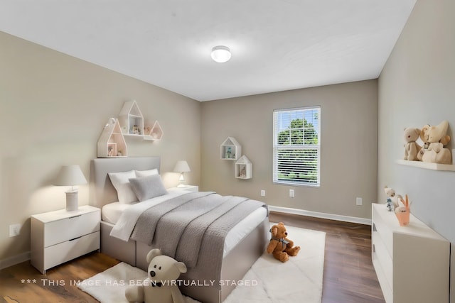 bedroom with dark wood finished floors and baseboards