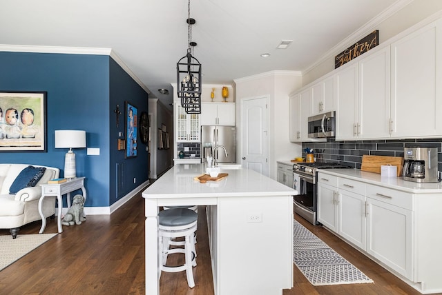 kitchen featuring ornamental molding, appliances with stainless steel finishes, dark wood finished floors, and visible vents