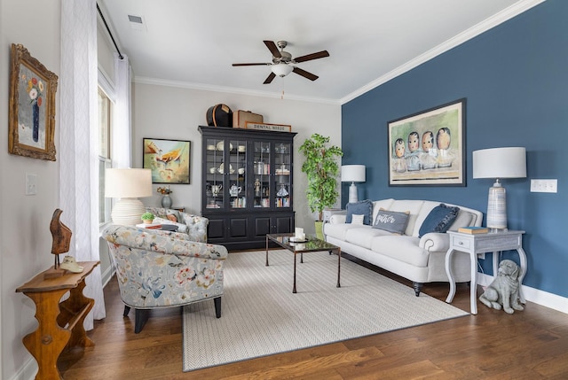 living area featuring wood finished floors, visible vents, and crown molding