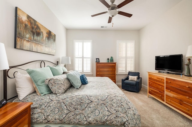 bedroom featuring ceiling fan, visible vents, baseboards, and light colored carpet