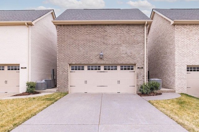 garage with driveway and central AC unit