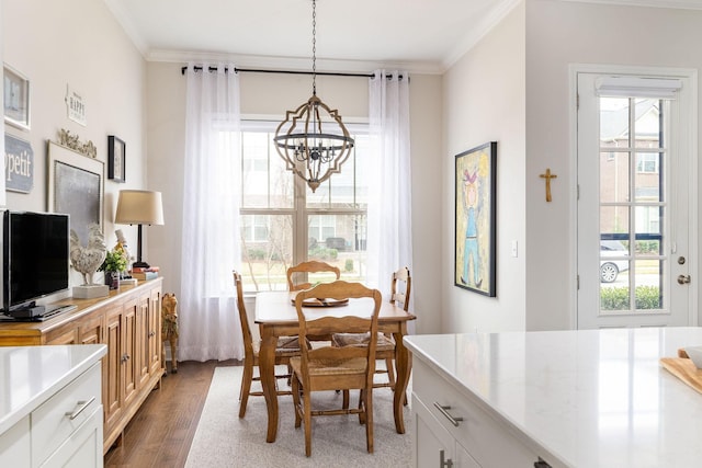 dining area featuring an inviting chandelier, ornamental molding, and wood finished floors