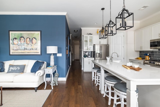 kitchen featuring visible vents, white cabinets, appliances with stainless steel finishes, dark wood-type flooring, and crown molding