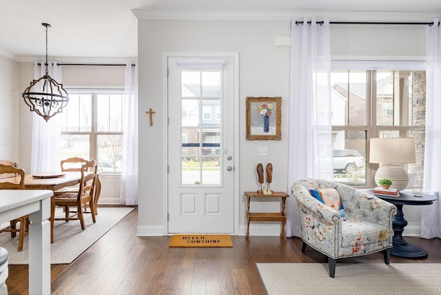 interior space featuring dark wood-type flooring, crown molding, and baseboards