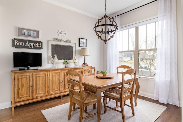 dining space featuring an inviting chandelier, baseboards, ornamental molding, and dark wood finished floors