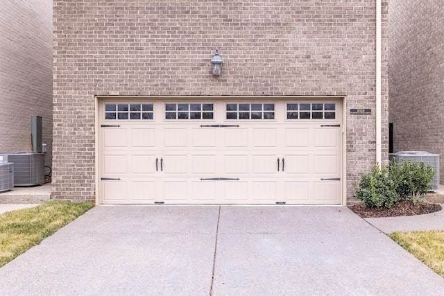 garage featuring central AC unit and concrete driveway