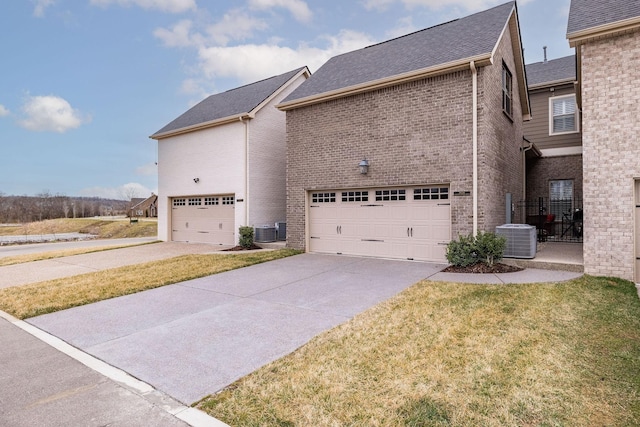 view of side of property featuring a garage, cooling unit, and brick siding