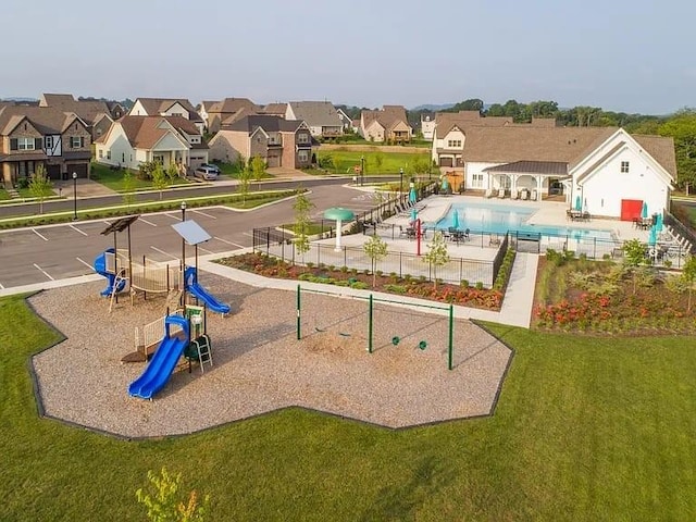 community play area featuring a residential view, a yard, and a community pool