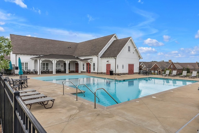 community pool with a patio area and fence