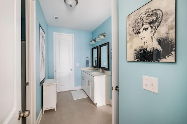 bathroom featuring vanity, visible vents, and baseboards