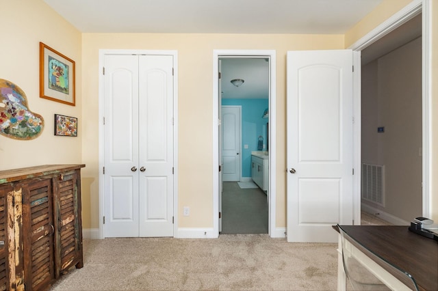 bedroom featuring light carpet, baseboards, visible vents, ensuite bath, and a closet