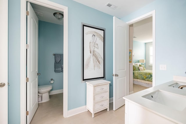 bathroom featuring toilet, a sink, visible vents, double vanity, and ensuite bath