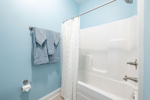 bathroom featuring baseboards and shower / tub combo with curtain