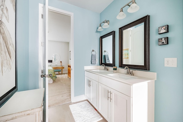 full bathroom featuring double vanity, baseboards, and a sink