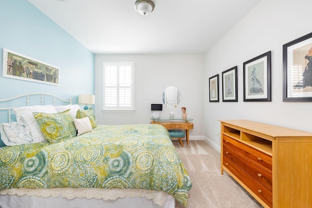 bedroom featuring light carpet and baseboards