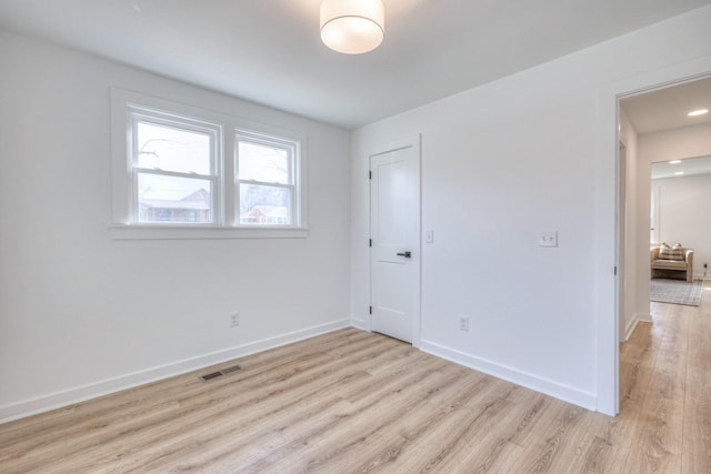 unfurnished bedroom with light wood-style floors, visible vents, and baseboards