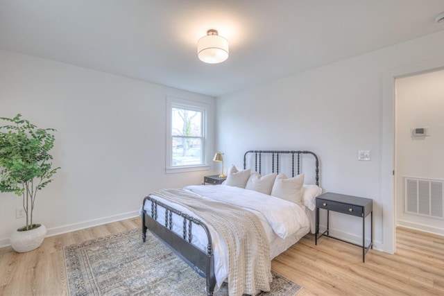 bedroom with light wood-style floors, baseboards, and visible vents