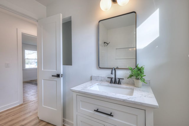 bathroom featuring vanity, baseboards, and wood finished floors