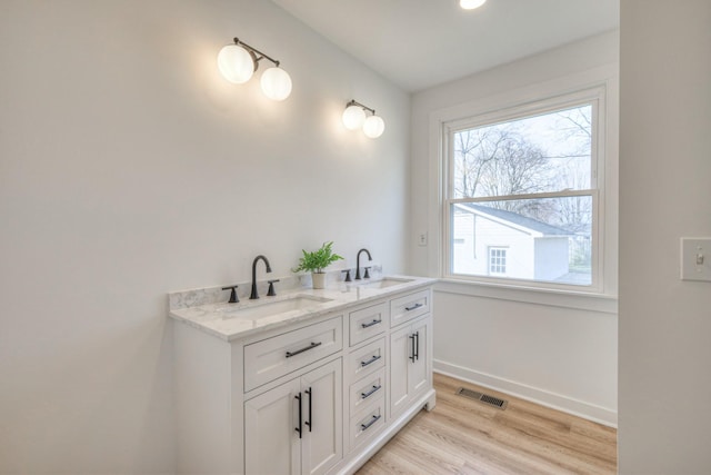 full bathroom featuring wood finished floors, a sink, visible vents, and baseboards