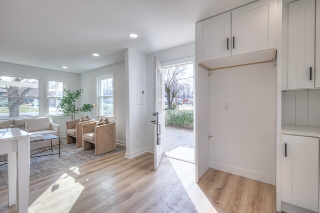 doorway featuring baseboards, recessed lighting, and light wood-style floors