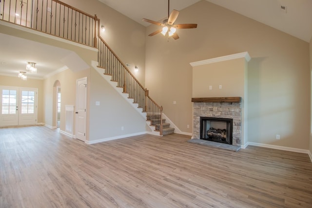 unfurnished living room with stairway, baseboards, wood finished floors, and a fireplace