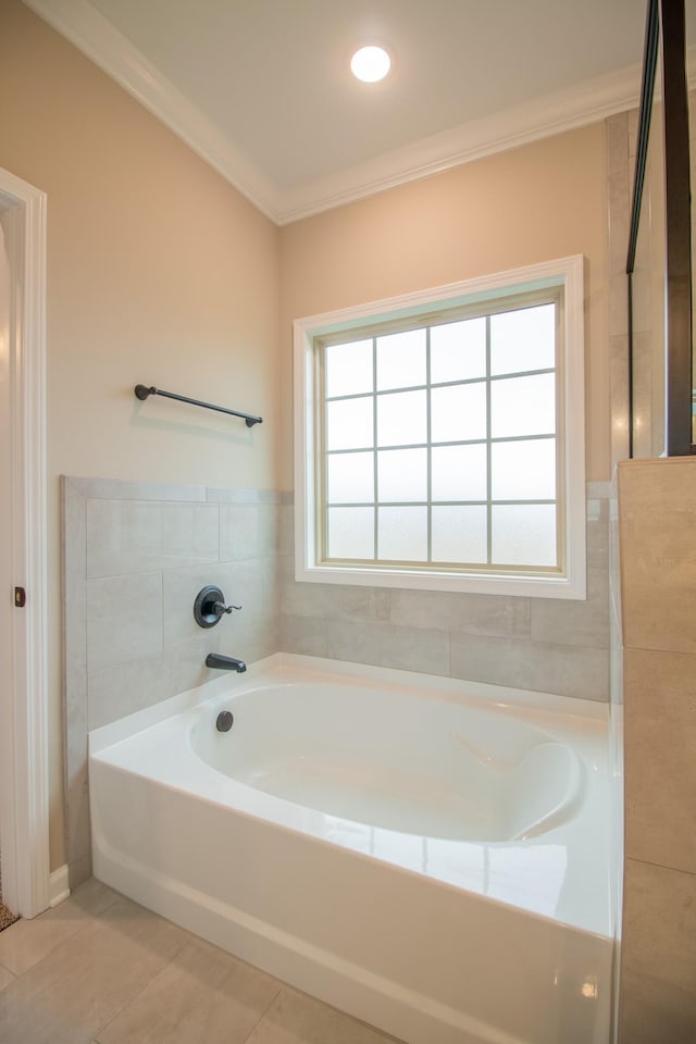 bathroom with a garden tub, crown molding, and tile patterned flooring