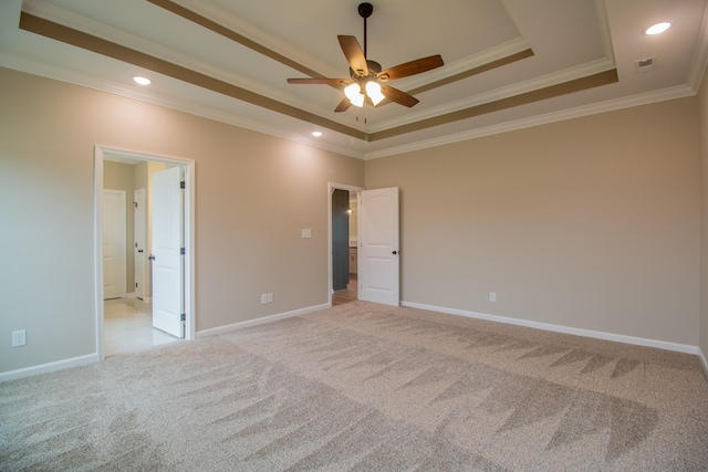 unfurnished bedroom featuring a tray ceiling, light carpet, baseboards, and crown molding