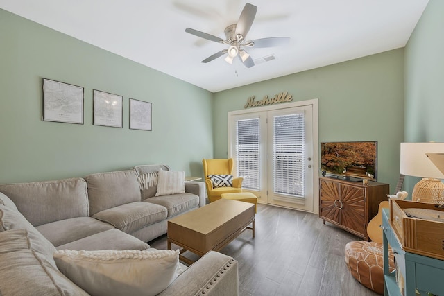 living room featuring a ceiling fan, visible vents, and wood finished floors