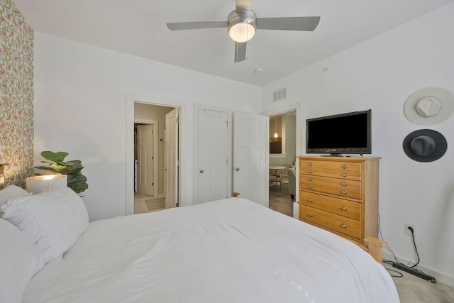 bedroom with ceiling fan, connected bathroom, visible vents, and baseboards