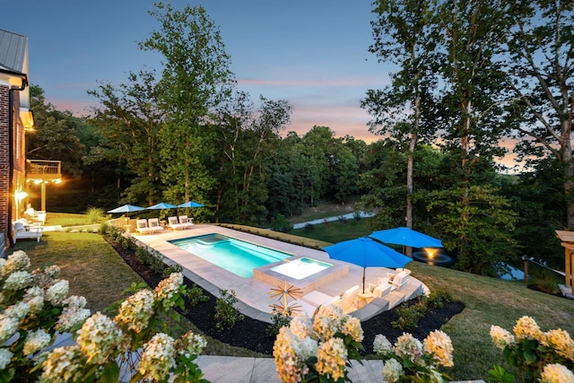 outdoor pool featuring a yard, a patio, and a jacuzzi