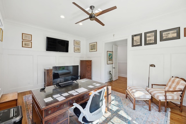 office space with recessed lighting, a decorative wall, ornamental molding, ceiling fan, and light wood-type flooring