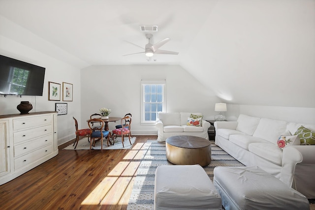 living room with ceiling fan, dark wood-style flooring, visible vents, baseboards, and vaulted ceiling