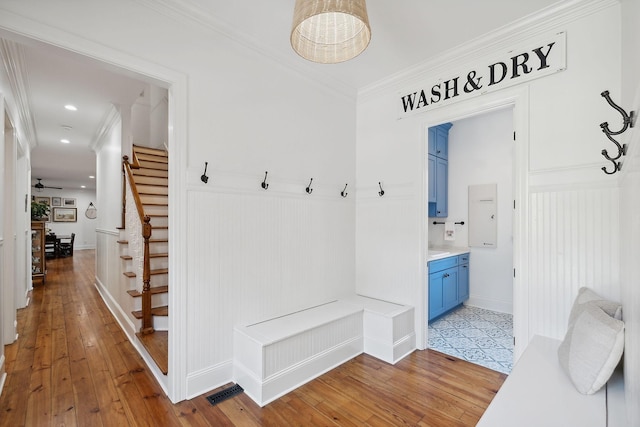 mudroom with light wood finished floors, visible vents, and ornamental molding