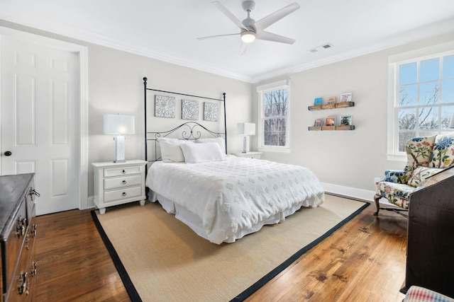 bedroom featuring light wood finished floors, visible vents, ornamental molding, a ceiling fan, and baseboards