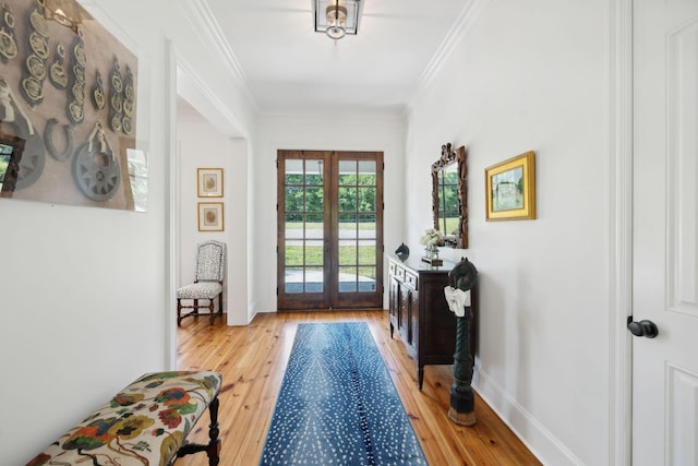 doorway with baseboards, french doors, light wood-style flooring, and crown molding