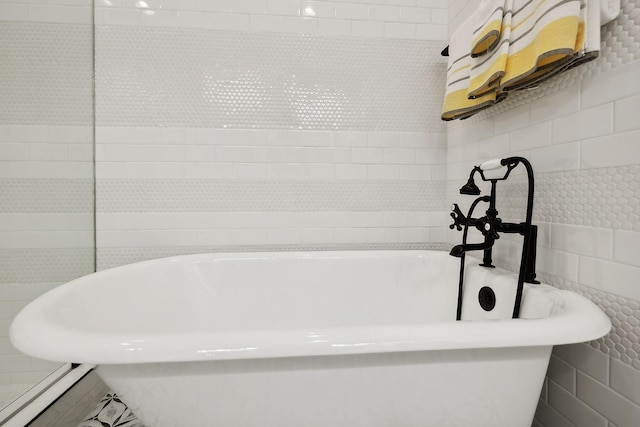 bathroom featuring a freestanding tub and tile walls