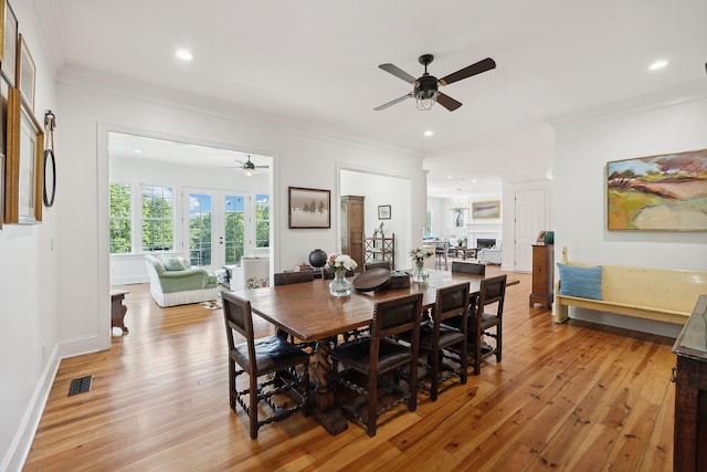 dining room with visible vents, baseboards, french doors, light wood-type flooring, and crown molding