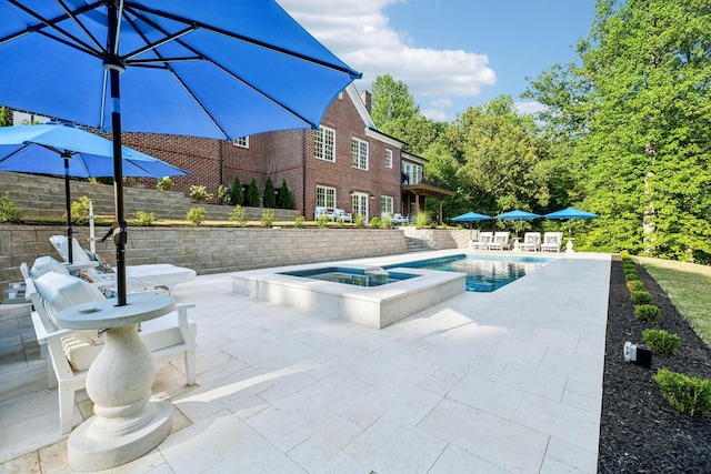 view of swimming pool featuring a pool with connected hot tub and a patio