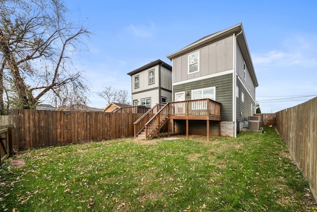 rear view of property featuring stairs, a deck, a lawn, and a fenced backyard