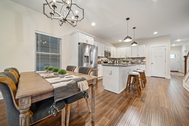 dining room with dark wood-style floors, baseboards, and recessed lighting